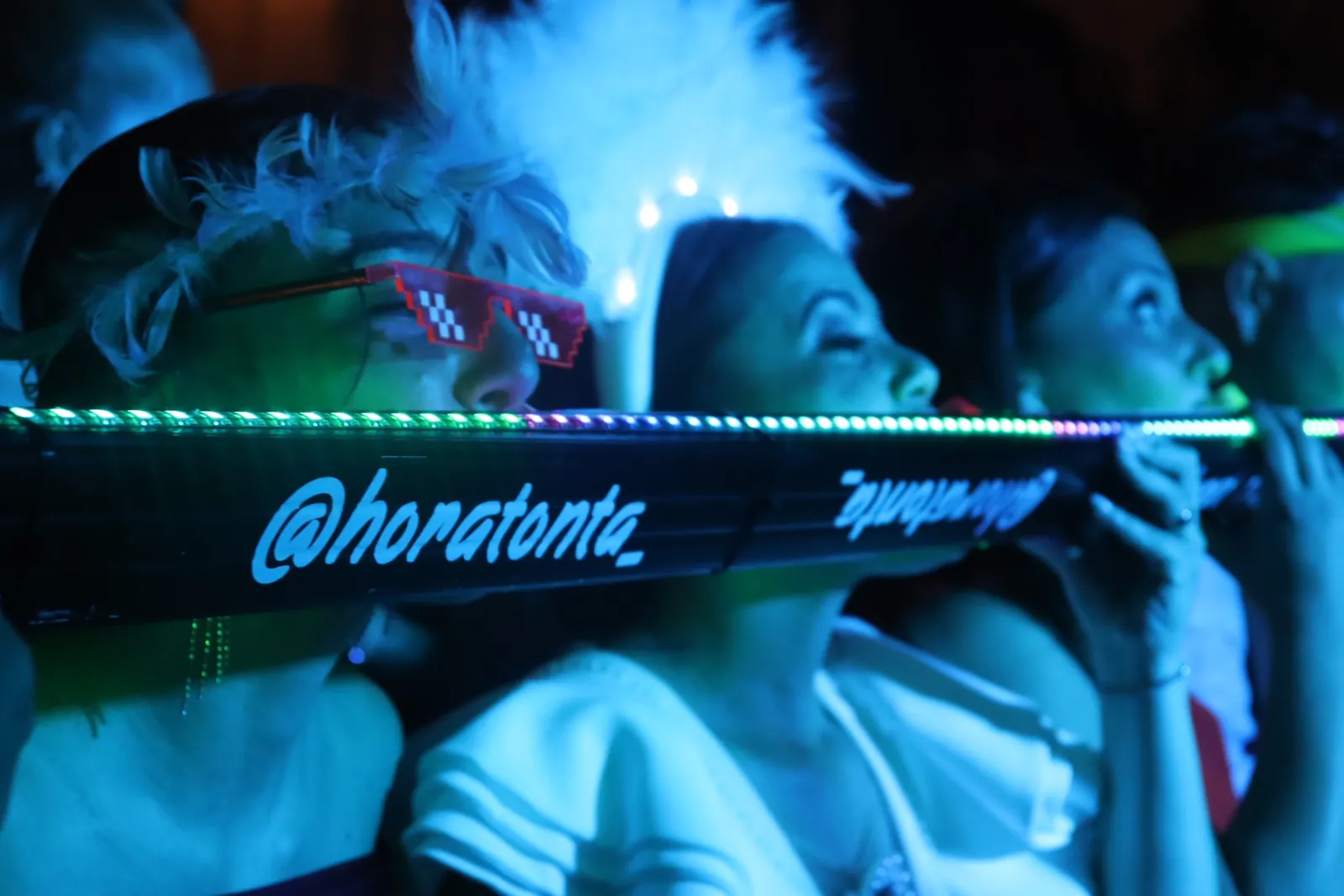 Detalle de un artista del catálogo Hora Tonta con elementos luminosos y plumas